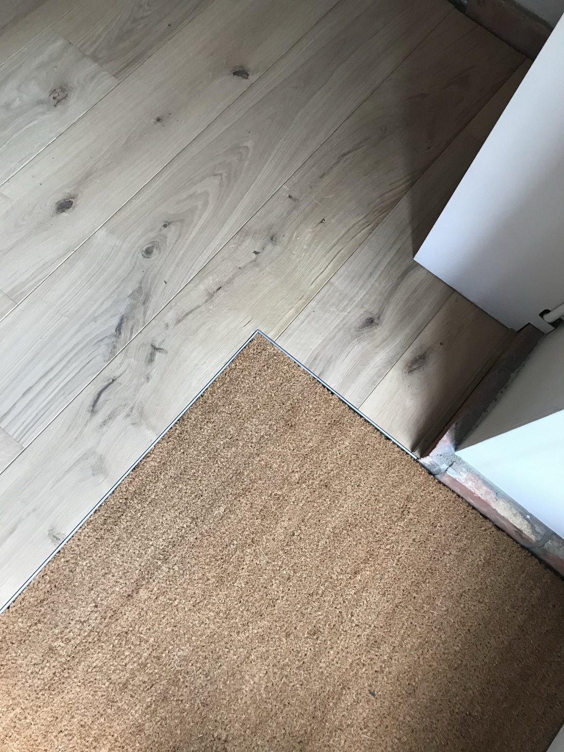 Raccord précis entre un parquet en chêne et une zone en liège