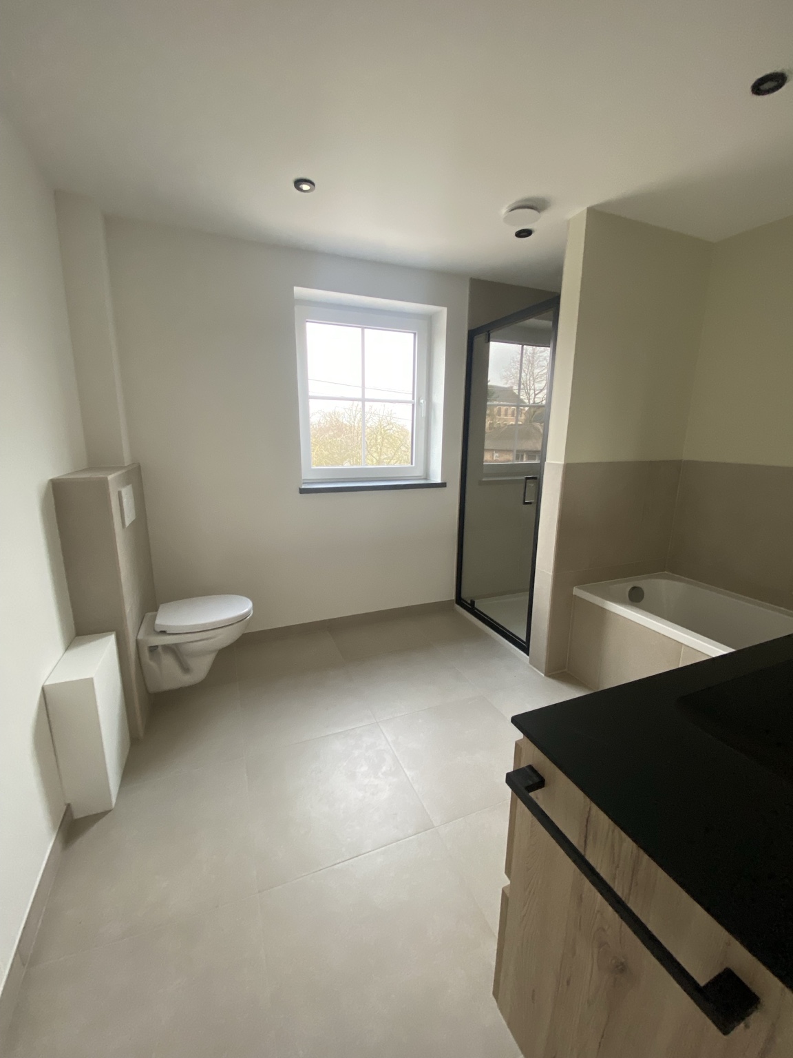 Vue d’ensemble d’une salle de bain claire avec douche et baignoire