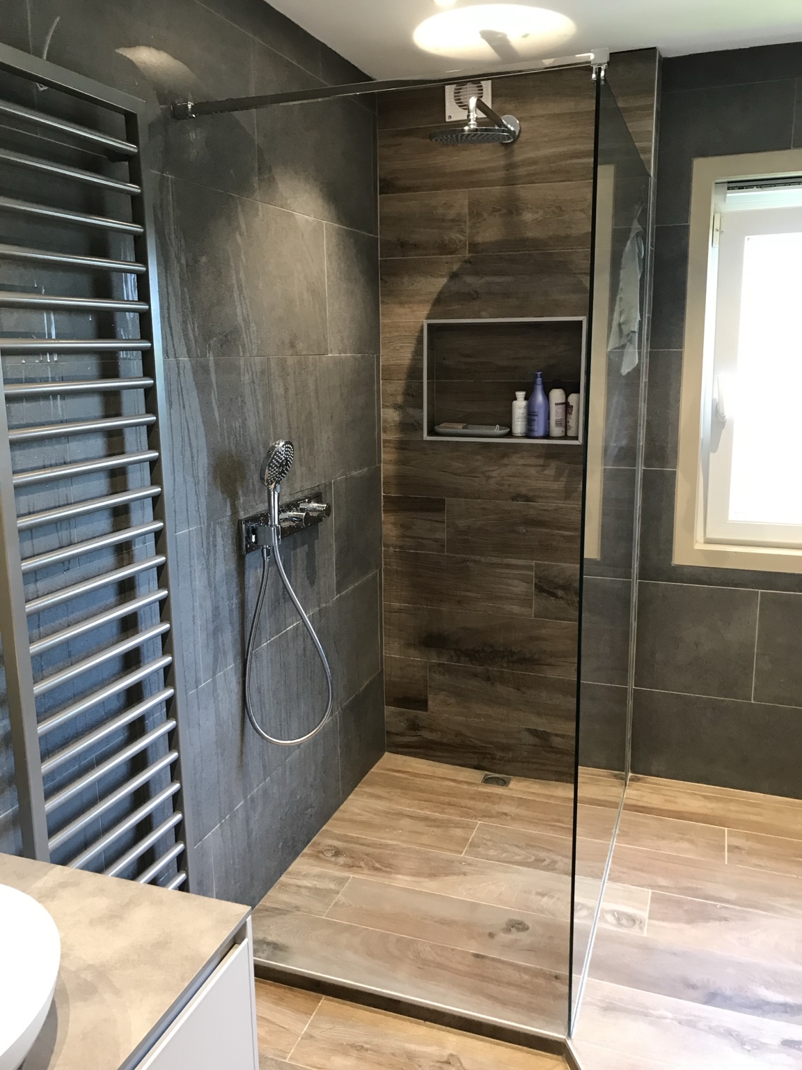 Douche italienne avec carrelage gris et finition effet bois