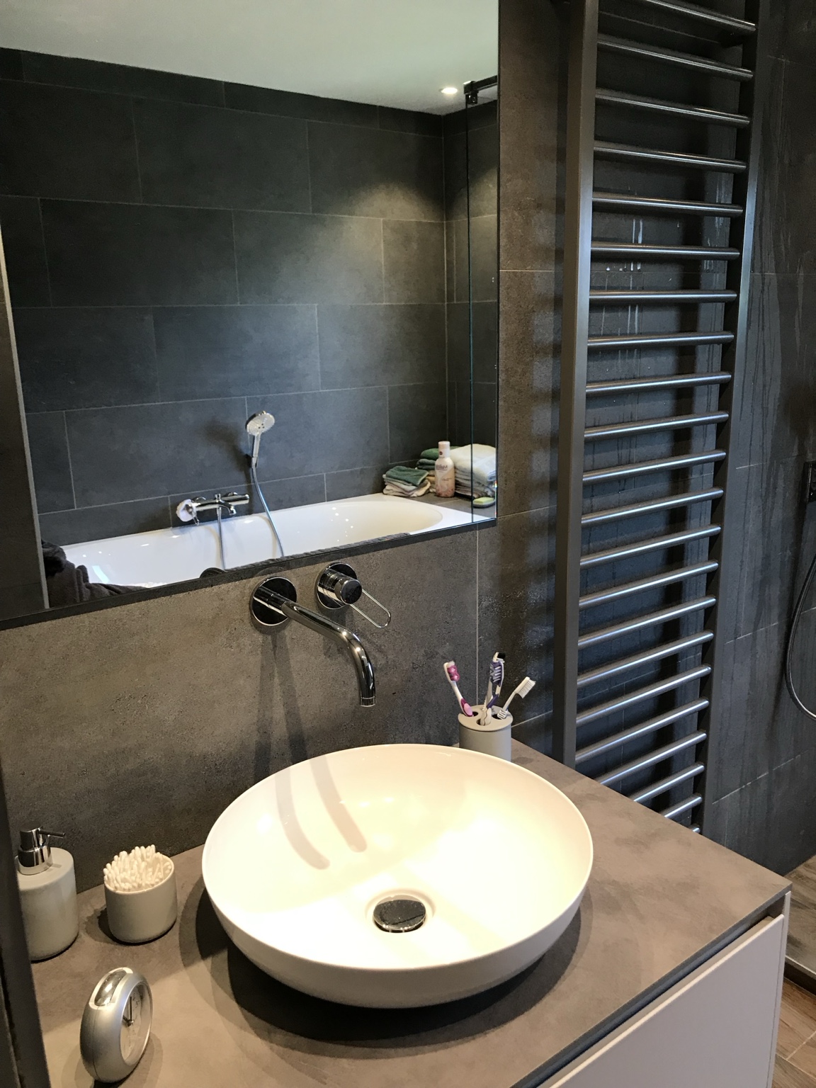 Vasque et baignoire dans une salle de bain carrelée gris anthracite
