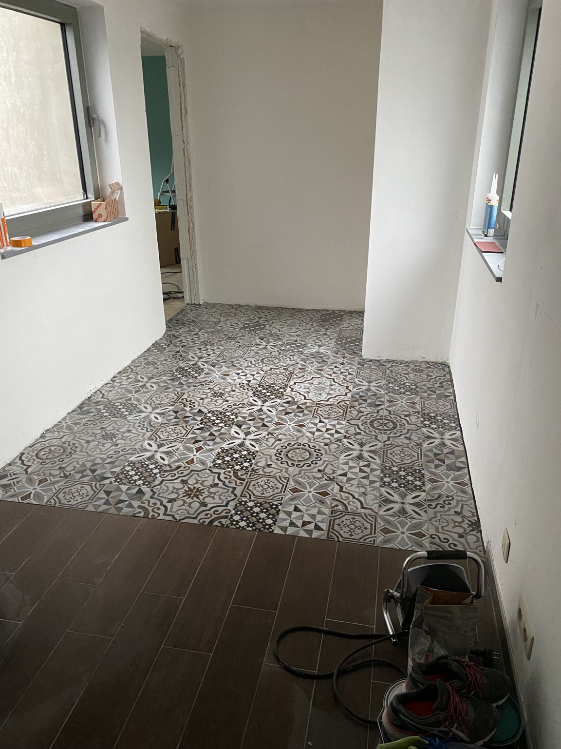 Sol intérieur associant carrelage imitation bois et carreaux décoratifs