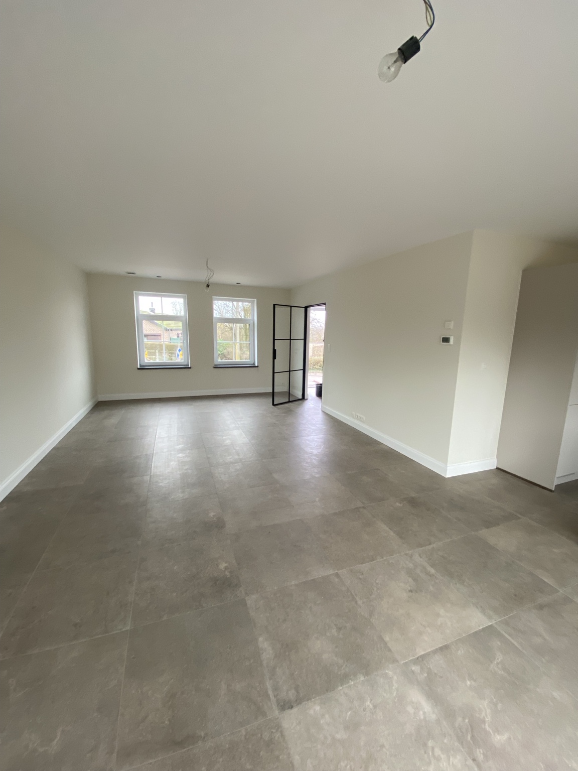 Grand carrelage clair posé dans un séjour lumineux